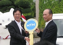 NTN Managing Director Terasaka (right) handing Iwata City Mayor Watanabe (left) the key