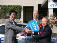 写真：鈴木会長（右）とタジマモーターコーポレーション田嶋会長（中央）から渡部市長へキーを手渡し