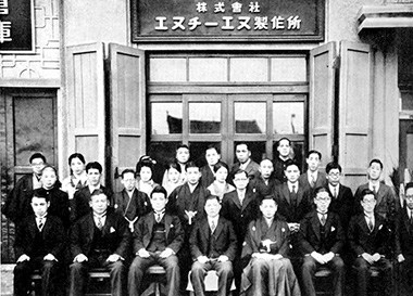 集合写真: 1937年、当時の本社ビル前にて（大阪市北区堂島）